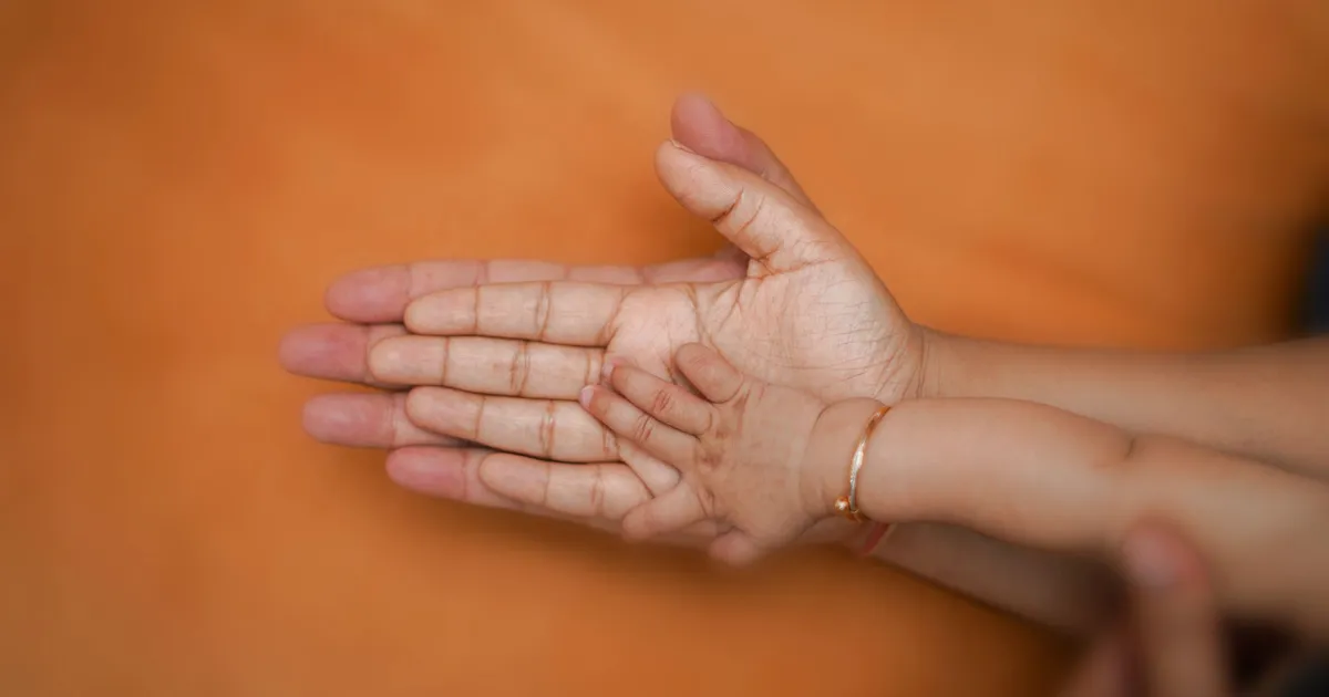 Main d'adulte soutenant la main d'un enfant, accompagnement d'un proche épileptique par la médecine prophétique