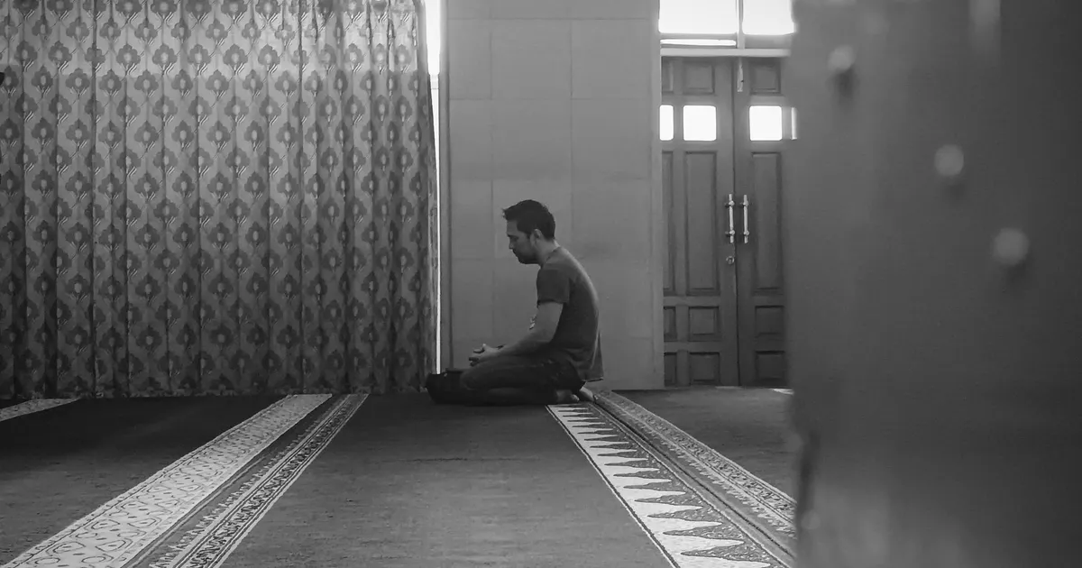 Homme assis seul en invocation dans une mosquée, santé mentale et foi du musulman